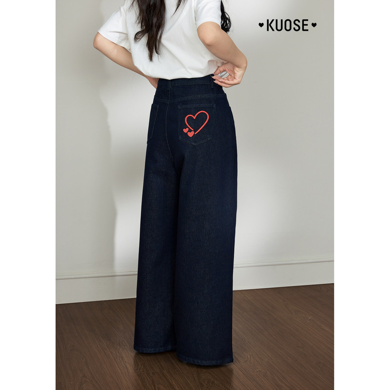 Model wearing dark wide-leg denim jeans with a heart back pocket design