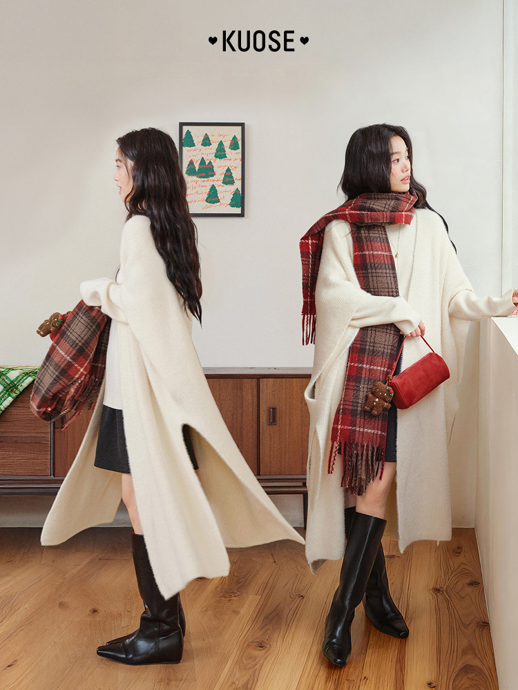 Cream oversized cape-style coat worn by a model with a plaid scarf