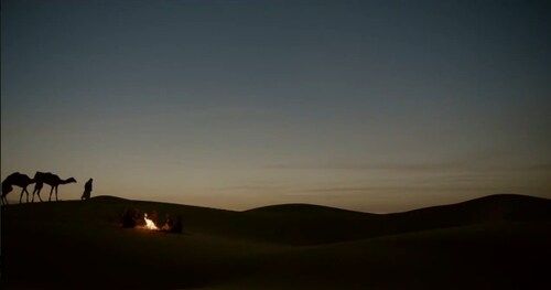 恶劣沙漠环境夕阳下骑着骆驼沙漠行走丝绸之路相关高清视频素材