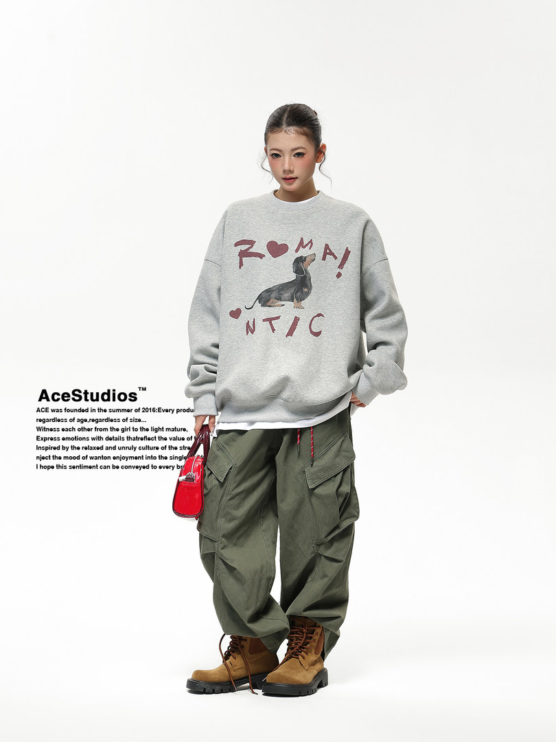 Model wearing a gray graphic sweatshirt with olive cargo pants and brown boots