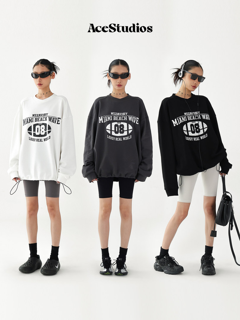 Oversized graphic long-sleeve sweatshirt worn by models in black, white, and charcoal