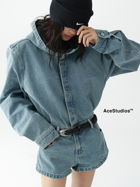 Woman wearing an oversized denim hoodie and denim shorts on a white background