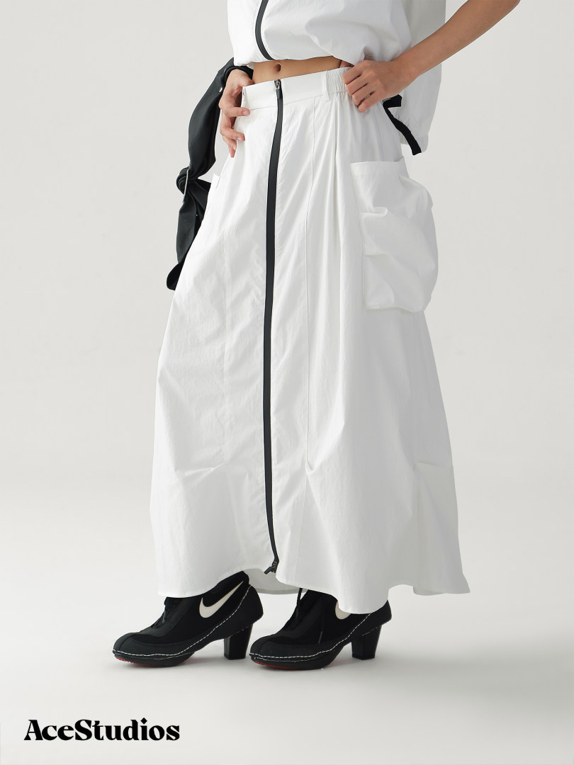 White long skirt with black zipper detail and large pockets worn on a model