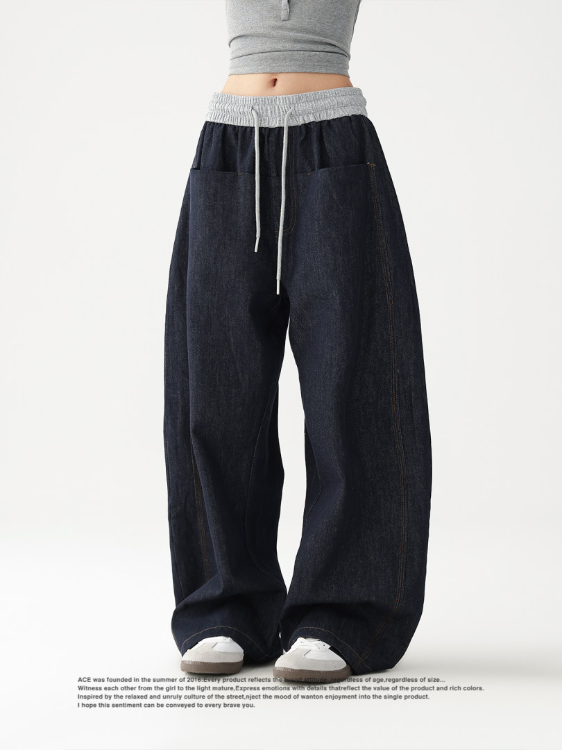 Dark wide-leg denim pants worn by a model