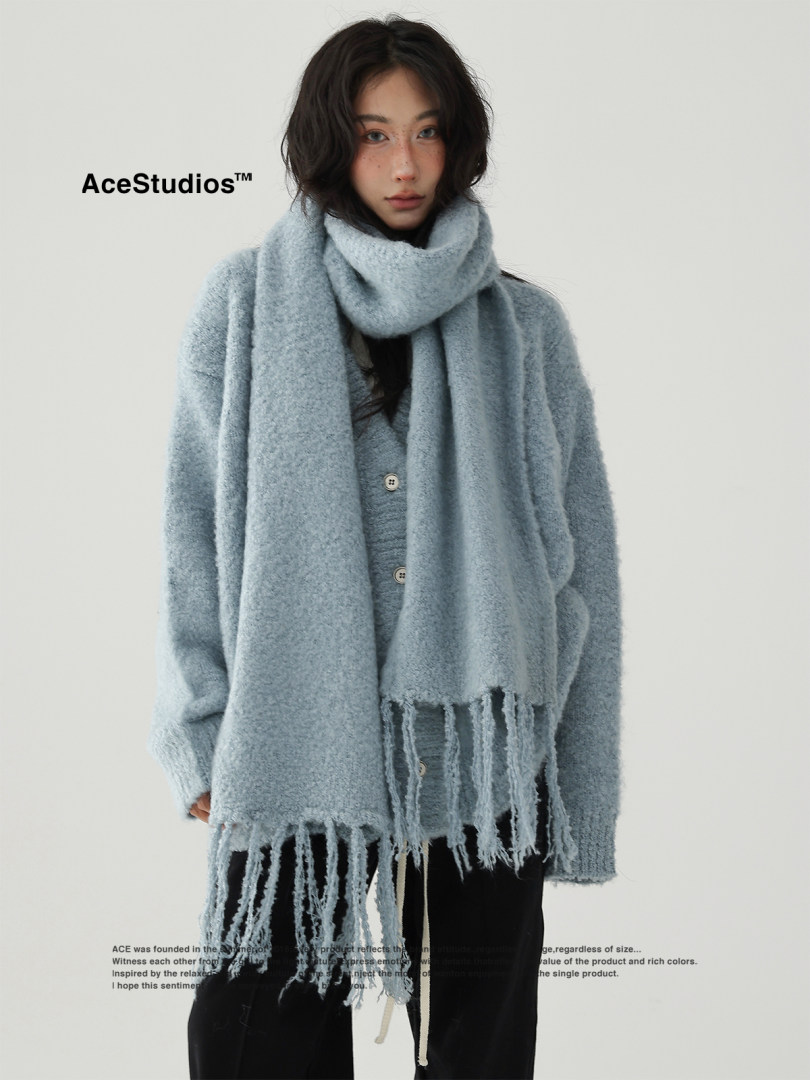 Model wearing a light blue fuzzy oversized scarf and matching knit sweater
