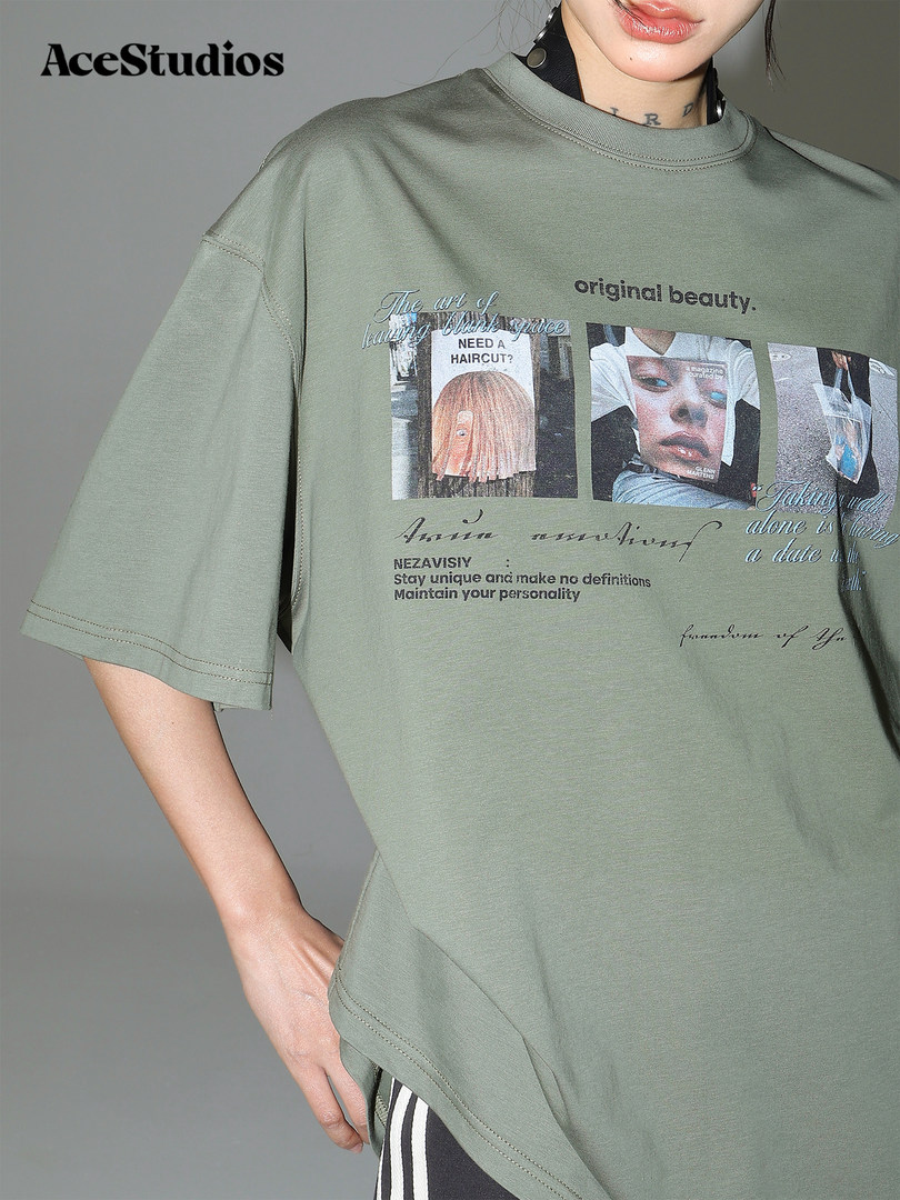 Model wearing a sage green graphic oversized T-shirt with printed text and images