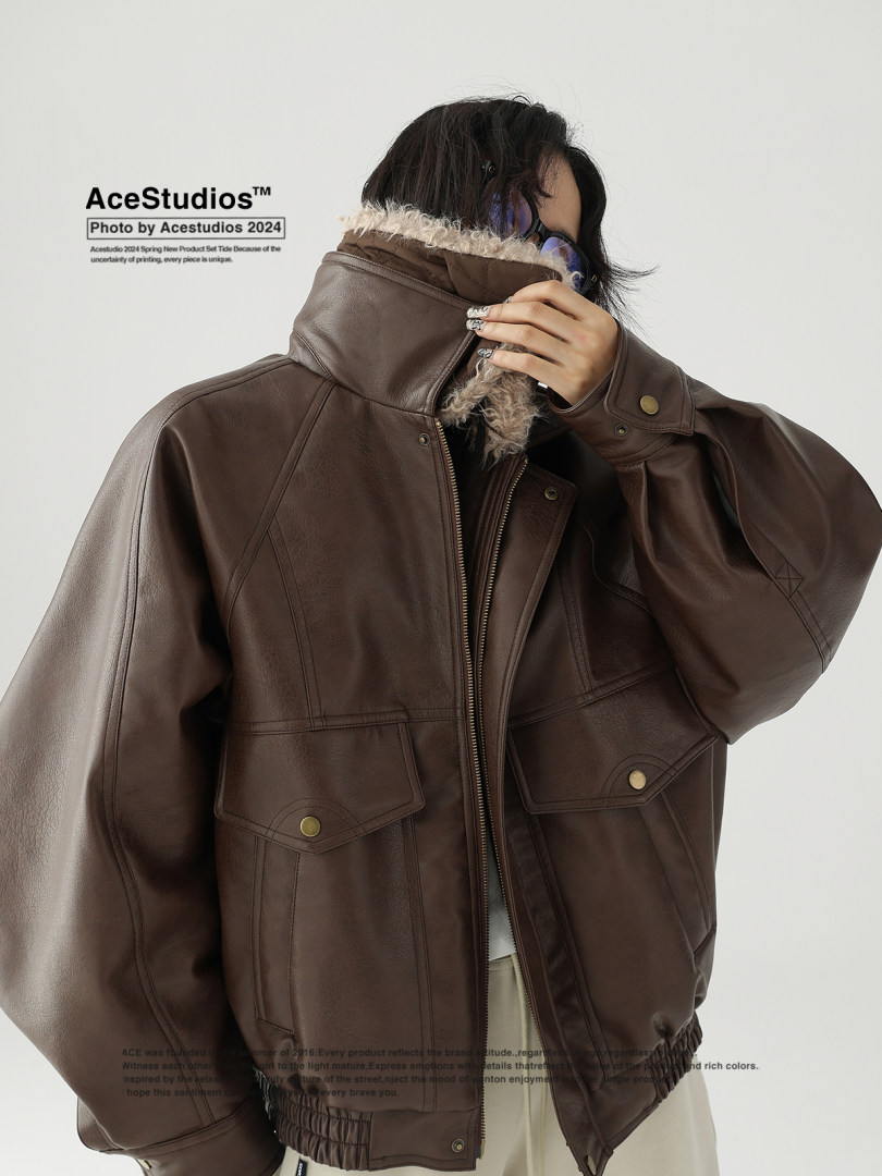 Model wearing a brown leather jacket with a high collar and shearling lining