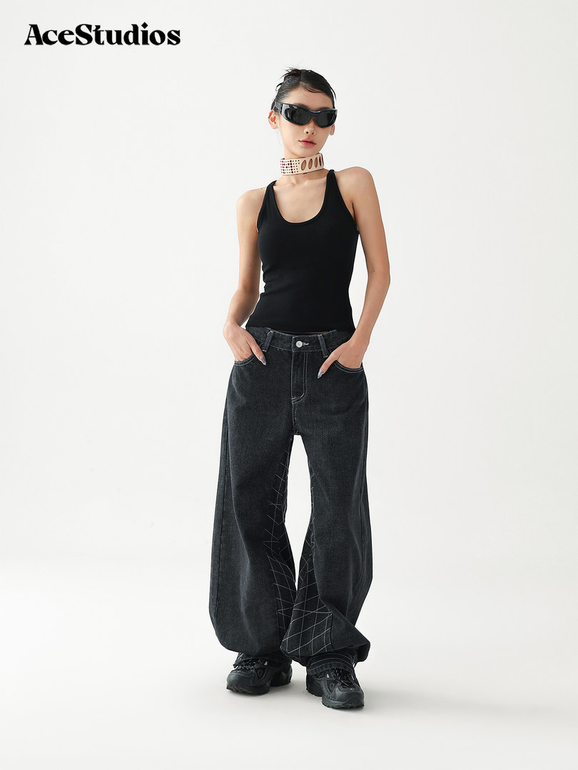 Model wearing a black tank top and oversized black jeans with sunglasses