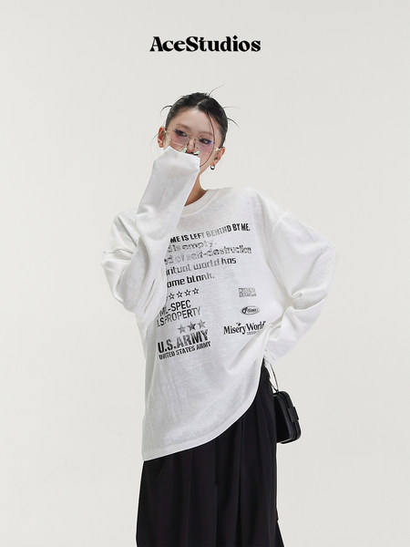 Model wearing a white oversized graphic long-sleeve top with black skirt