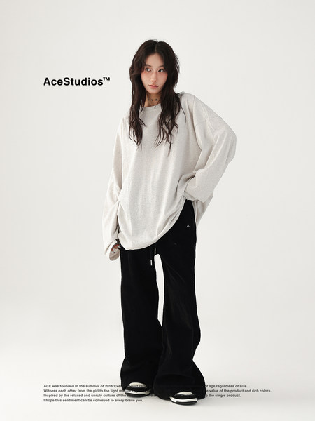 Model wearing an oversized light gray sweatshirt with black wide-leg pants