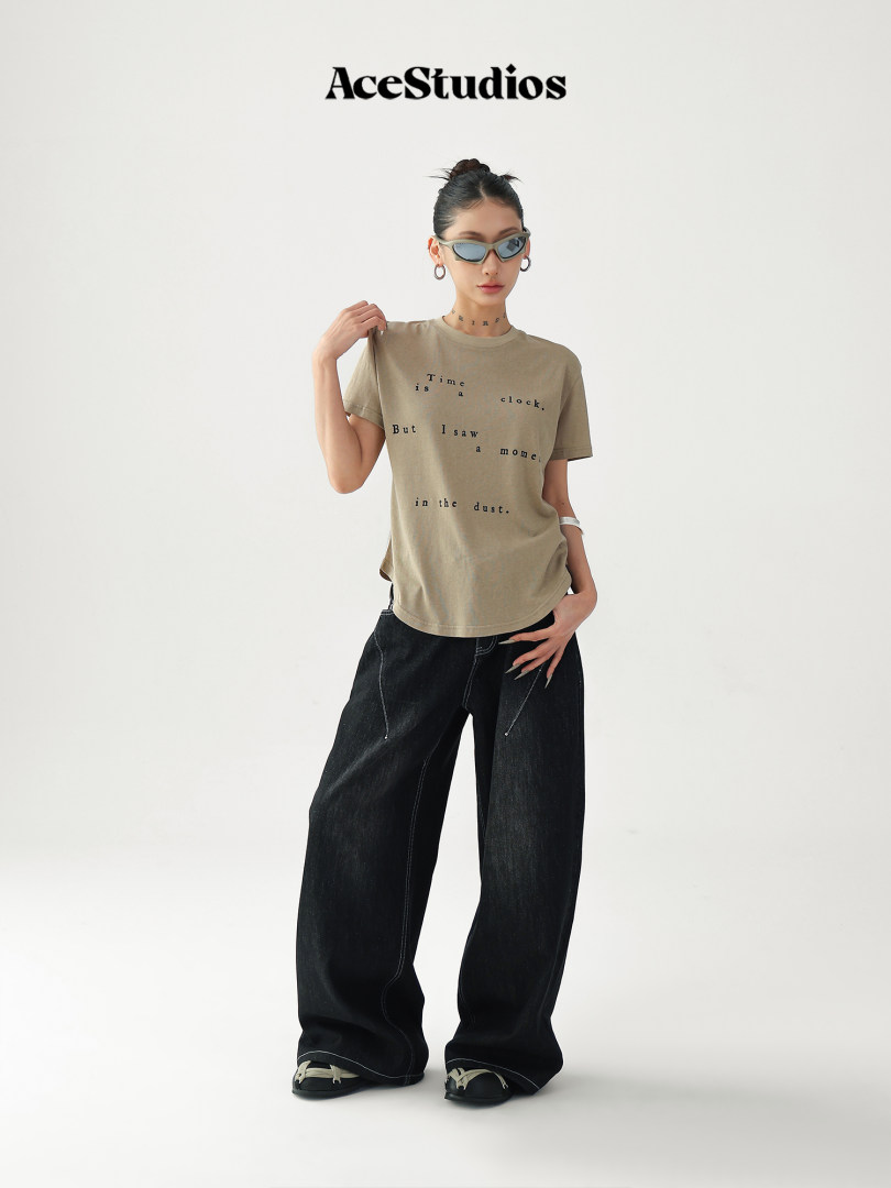 Model wearing a beige graphic T-shirt with black wide-leg jeans