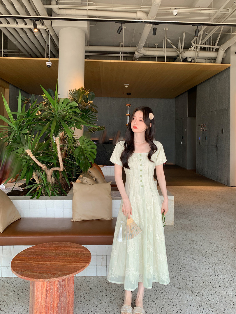 Model wearing a light mint lace midi dress with short sleeves and button front