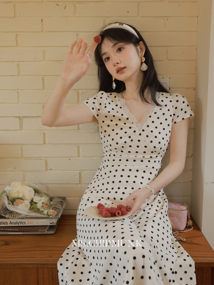 Woman wearing a white polka dot dress with lace detail