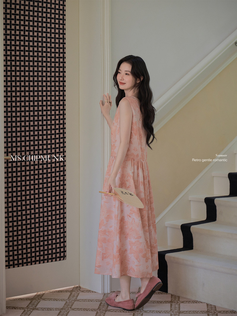 Model wearing a pink floral sleeveless midi dress indoors