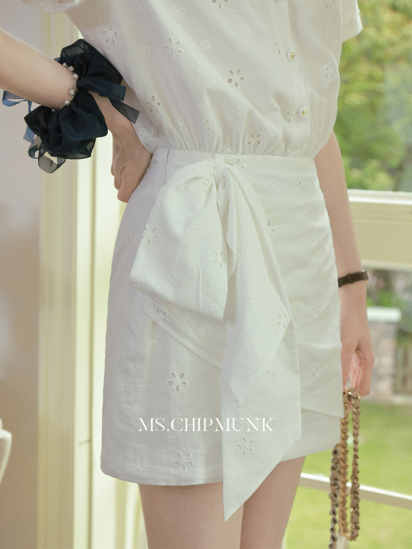 White embroidered tie-waist dress worn by a model