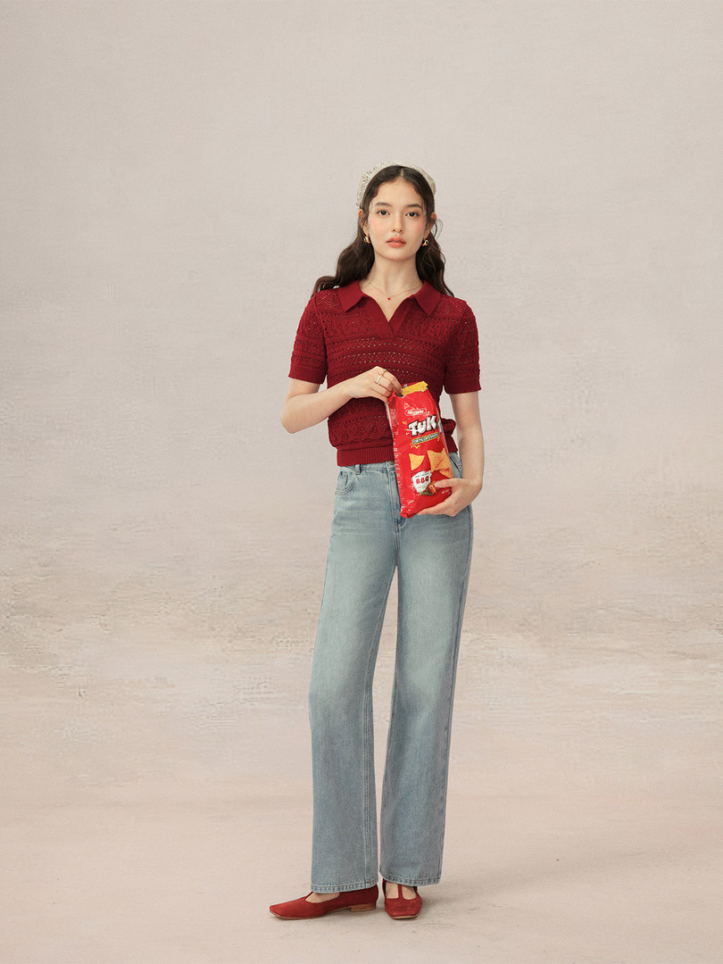 Model wearing a red knit polo top with light blue jeans and red flats