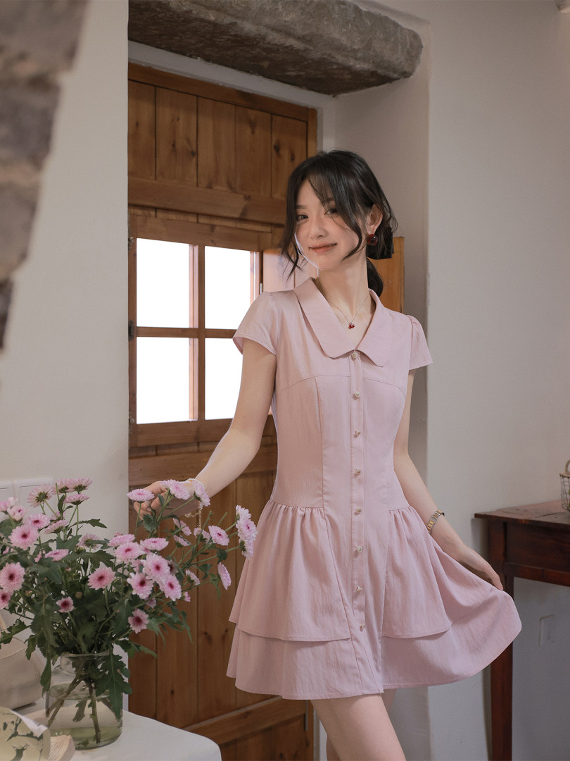 Young woman wearing a light pink short dress indoors