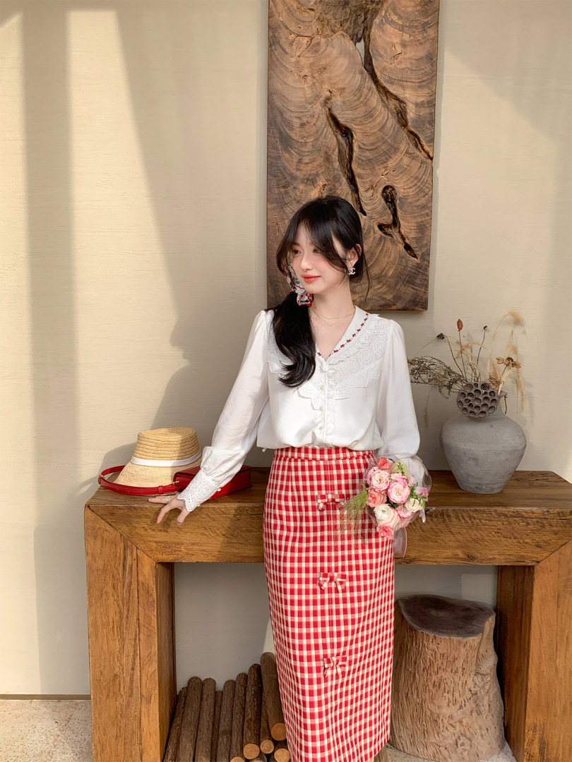 Woman wearing a white blouse and red gingham skirt