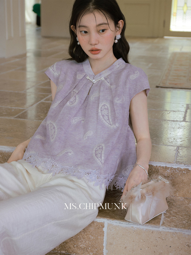 Model wearing a lavender sleeveless paisley top with lace trim