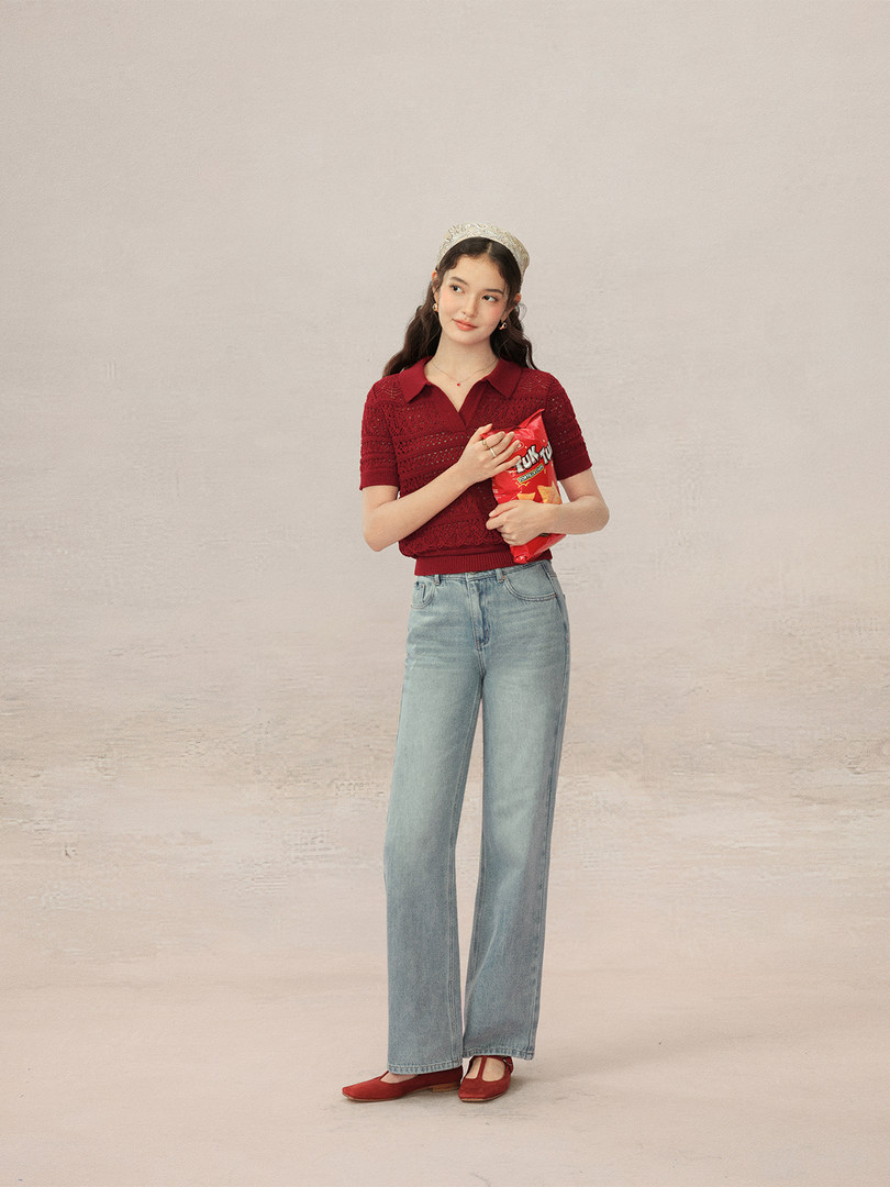 Model wearing a red short-sleeve knit top with light blue wide-leg jeans