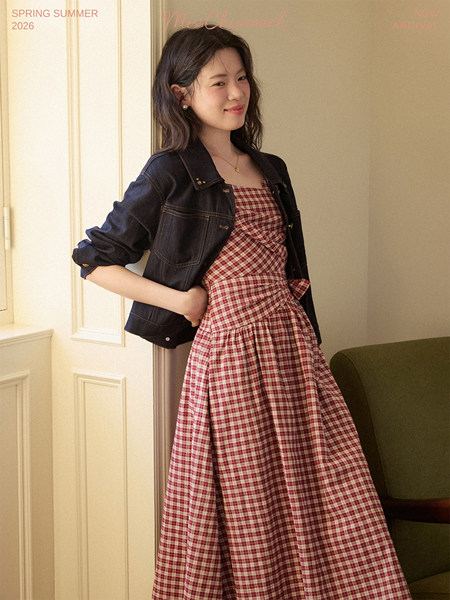 Model wearing a red plaid dress with a dark denim jacket