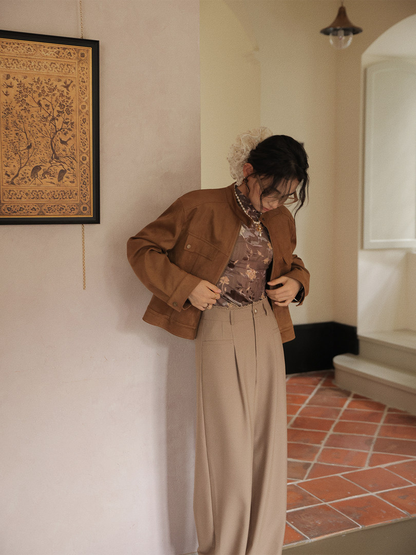 Model wearing a brown jacket with a floral top and beige wide-leg pants