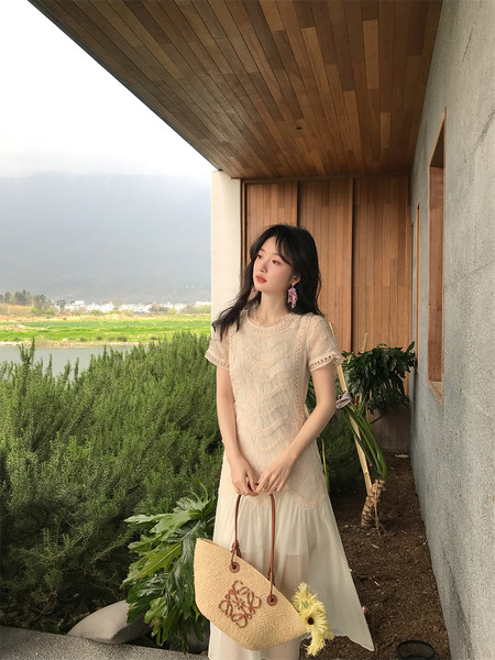 Woman wearing a cream lace maxi dress outdoors