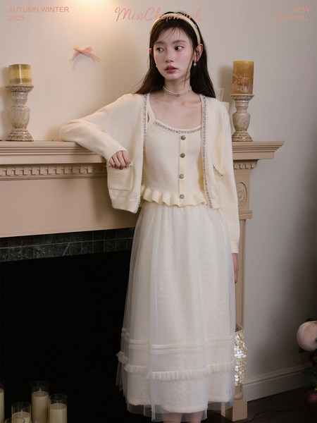 Model wearing a cream knit cardigan and dress set with decorative trim