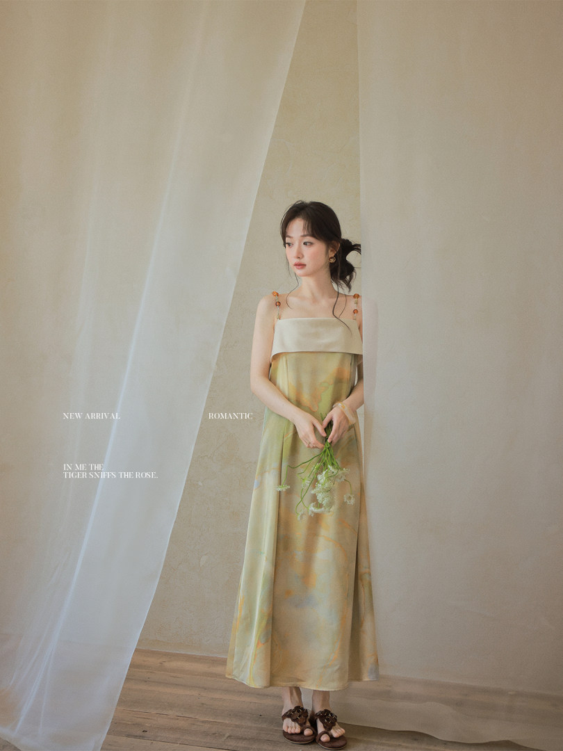 Woman wearing a pastel sleeveless midi dress holding flowers