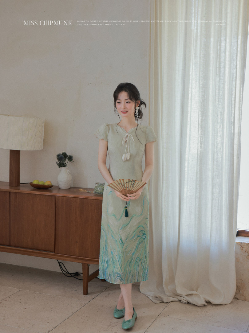 Model wearing a light green short-sleeve midi dress with a marbled print