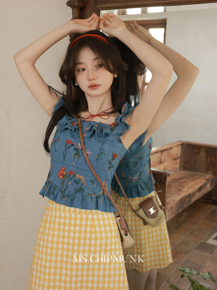 Model wearing a blue floral ruffled top with a yellow gingham skirt