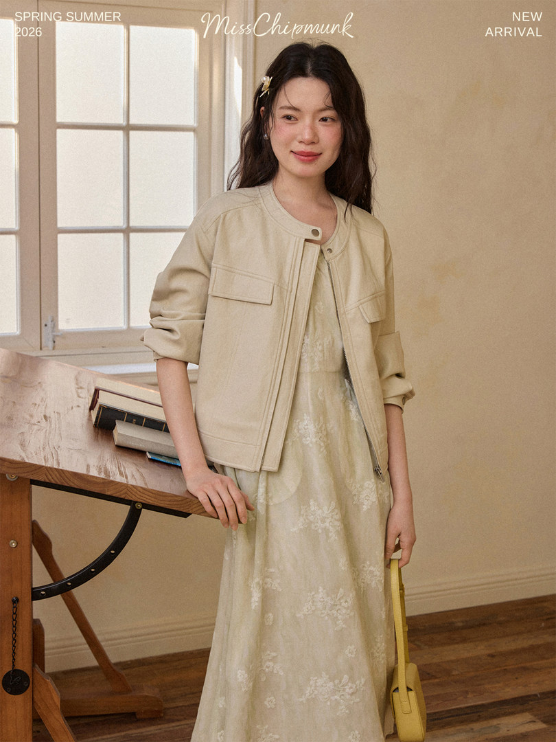 Woman wearing a beige jacket over a light floral dress in a spring summer fashion image