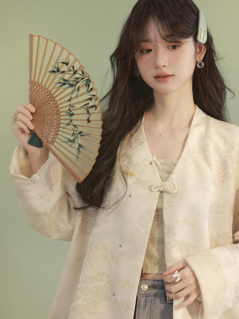 Model wearing a light cream traditional-style jacket and top