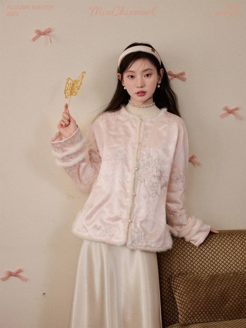 Model wearing a pale pink fuzzy button-up jacket with a long skirt