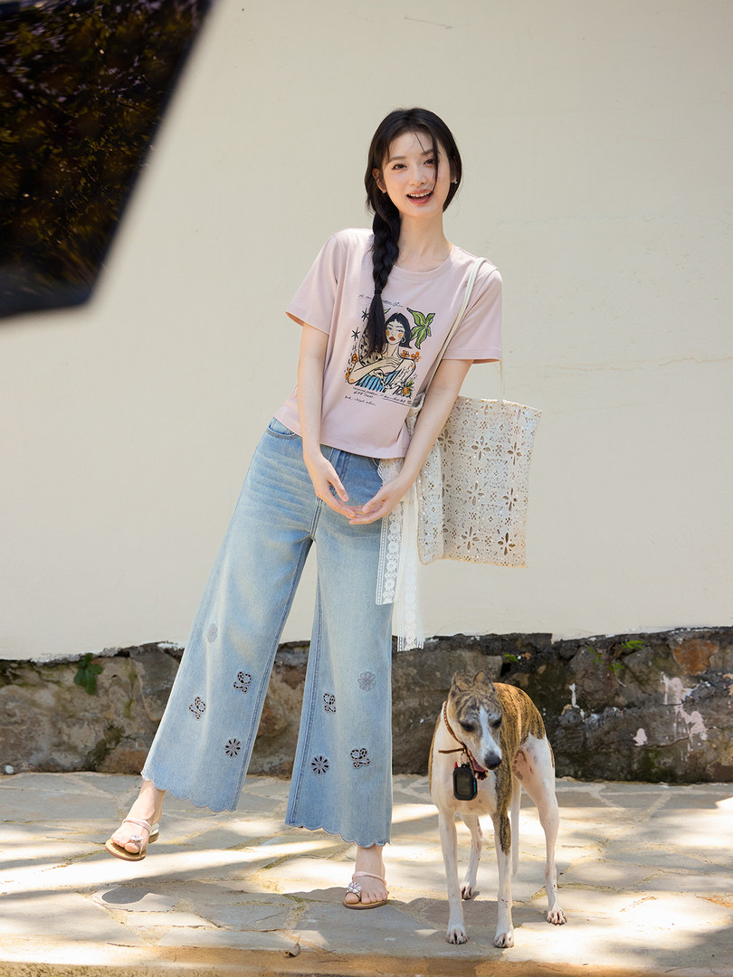 Model wearing a pink graphic T-shirt with light blue wide-leg jeans