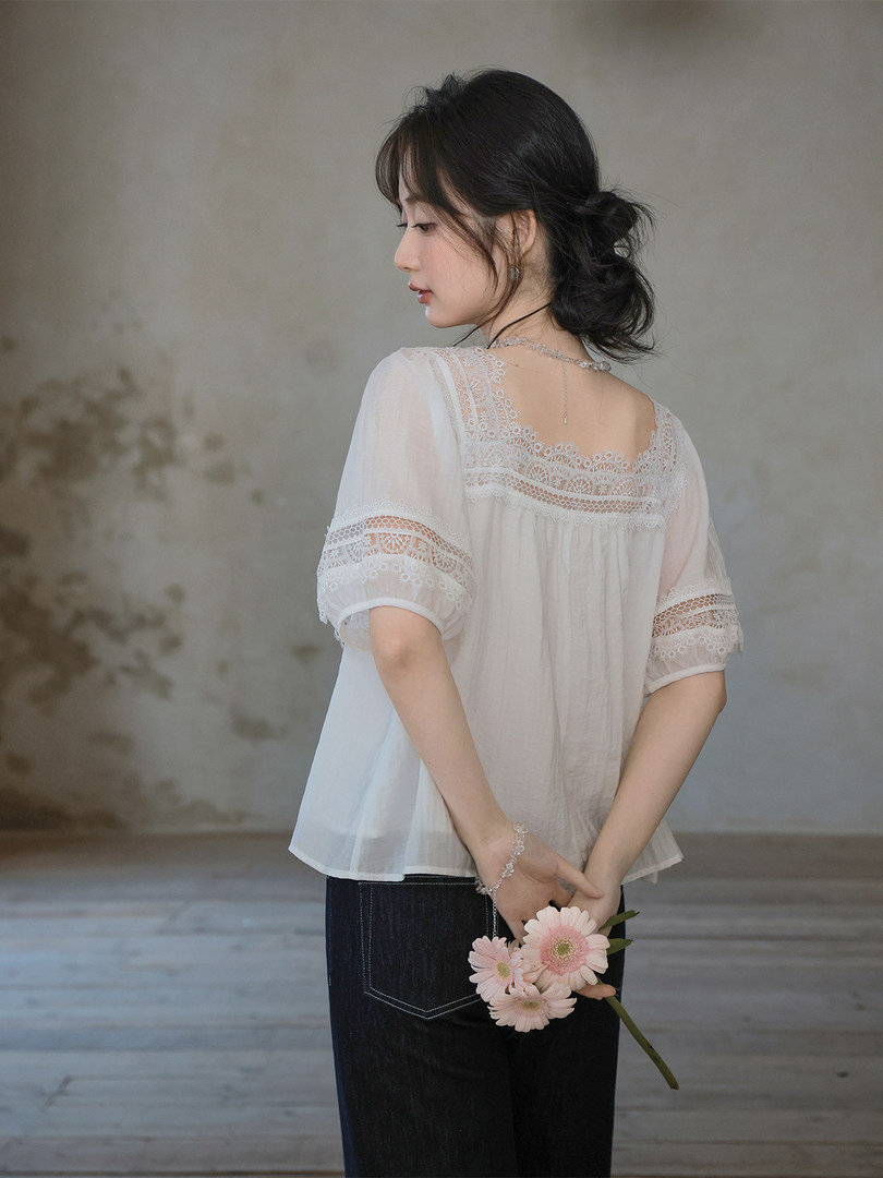 White lace blouse worn by a model with dark jeans