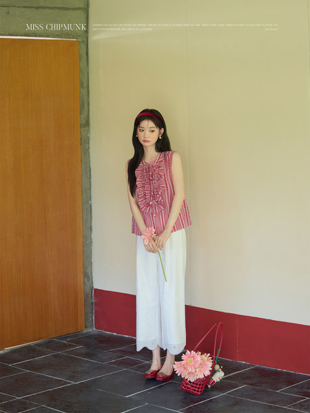 Model wearing a red gingham sleeveless top with white wide-leg pants
