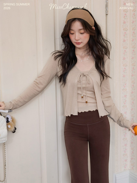 Model wearing a beige cardigan over a striped top and brown leggings