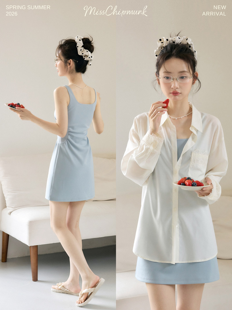 Model wearing a light blue dress with a white sheer shirt overlay in a studio setting
