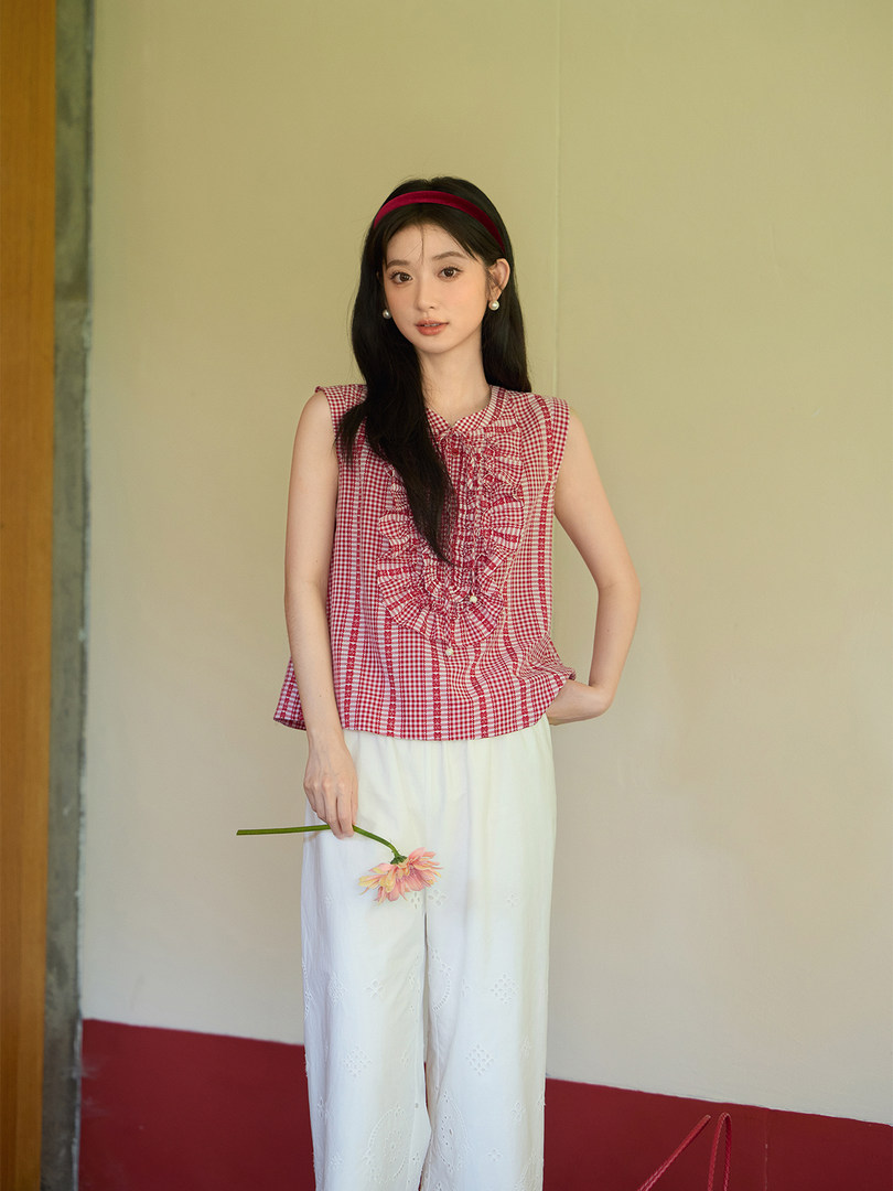 Model wearing a red gingham sleeveless top with white wide-leg pants