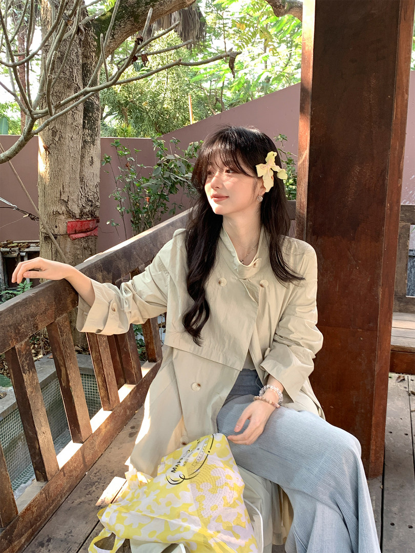 Woman wearing a light beige trench coat outdoors