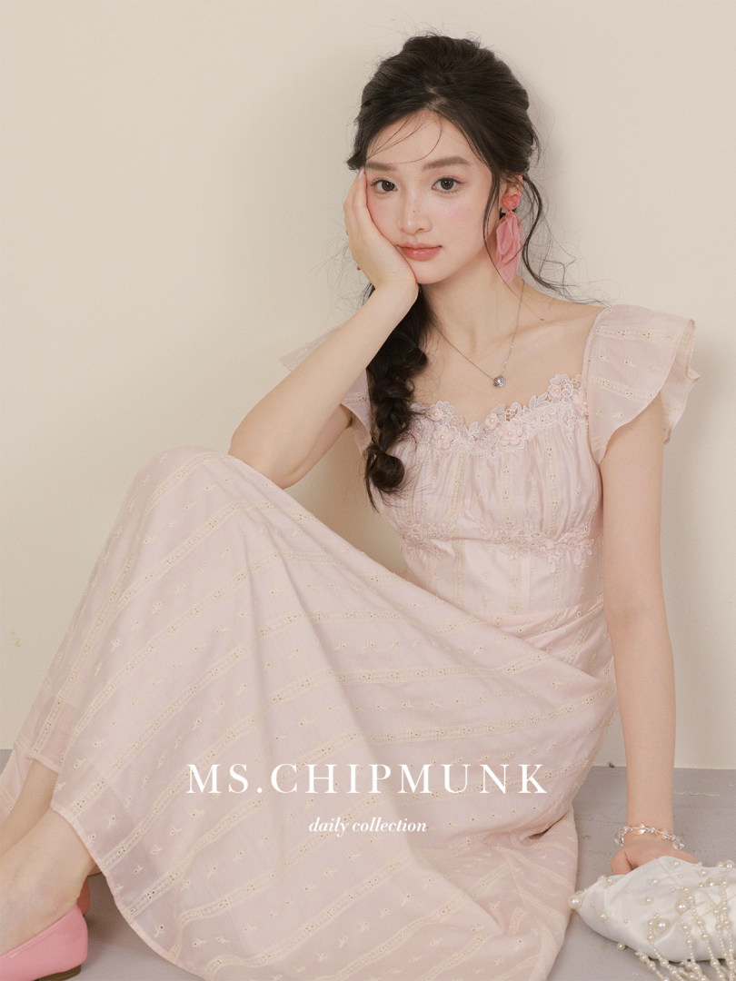 Model wearing a light pink lace dress with floral details.