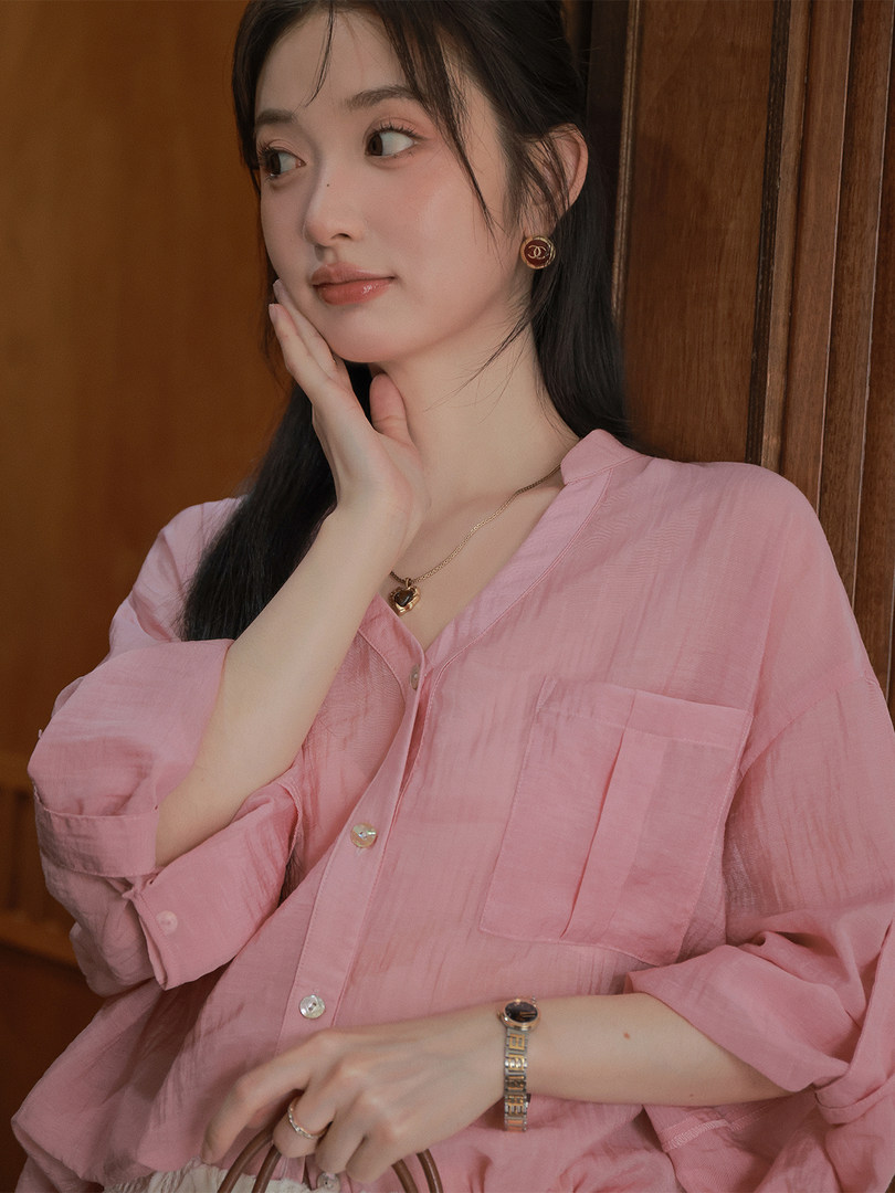 Woman wearing a pink loose button-up shirt