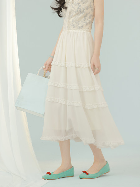 Cream ruffled midi dress worn with mint flats and a light blue shopping bag