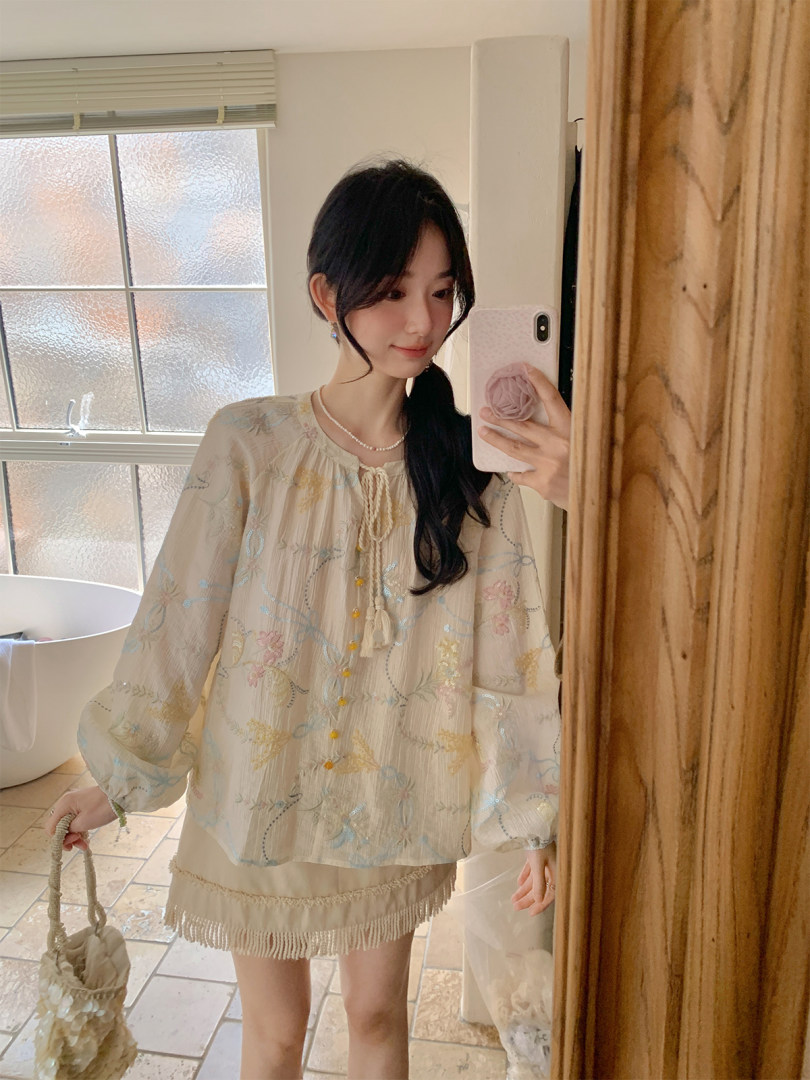 Woman wearing a light embroidered boho blouse and matching skirt in a mirror selfie