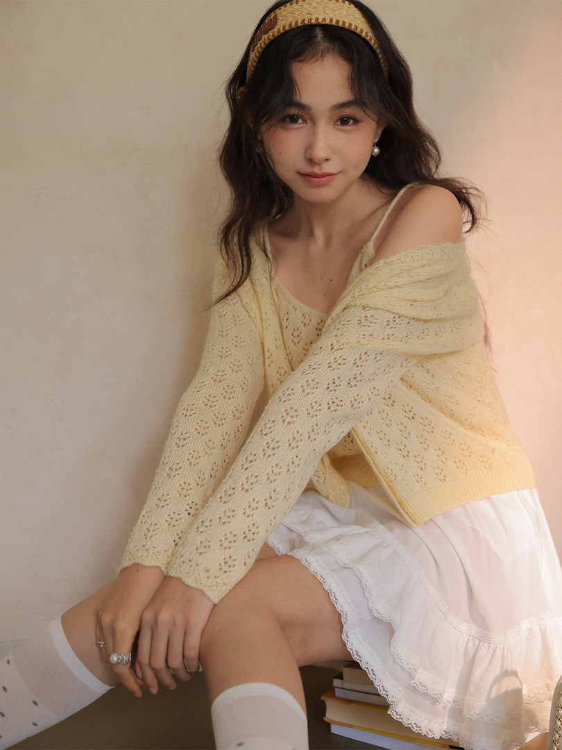 Model wearing a pale yellow knit cardigan with a white skirt and headband