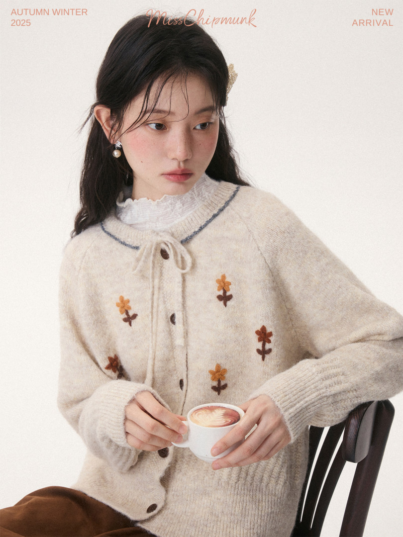 Model wearing a cream knitted floral cardigan with buttons and a bow tie detail
