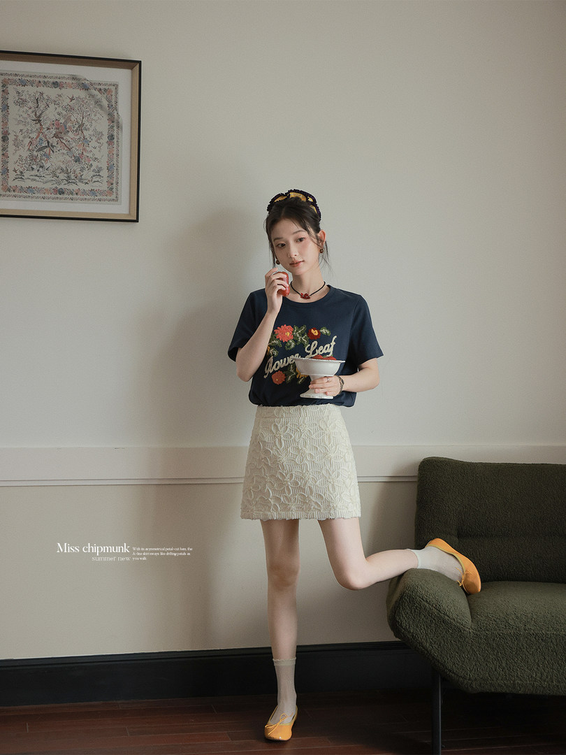 Model wearing a navy graphic T-shirt and cream lace mini skirt
