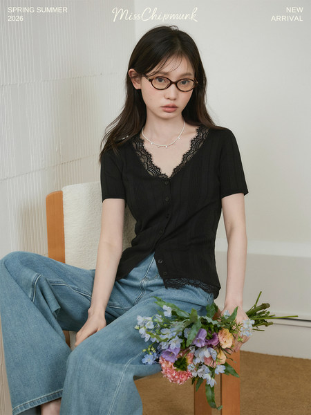Model wearing a black lace-trim short-sleeve button top with light blue jeans
