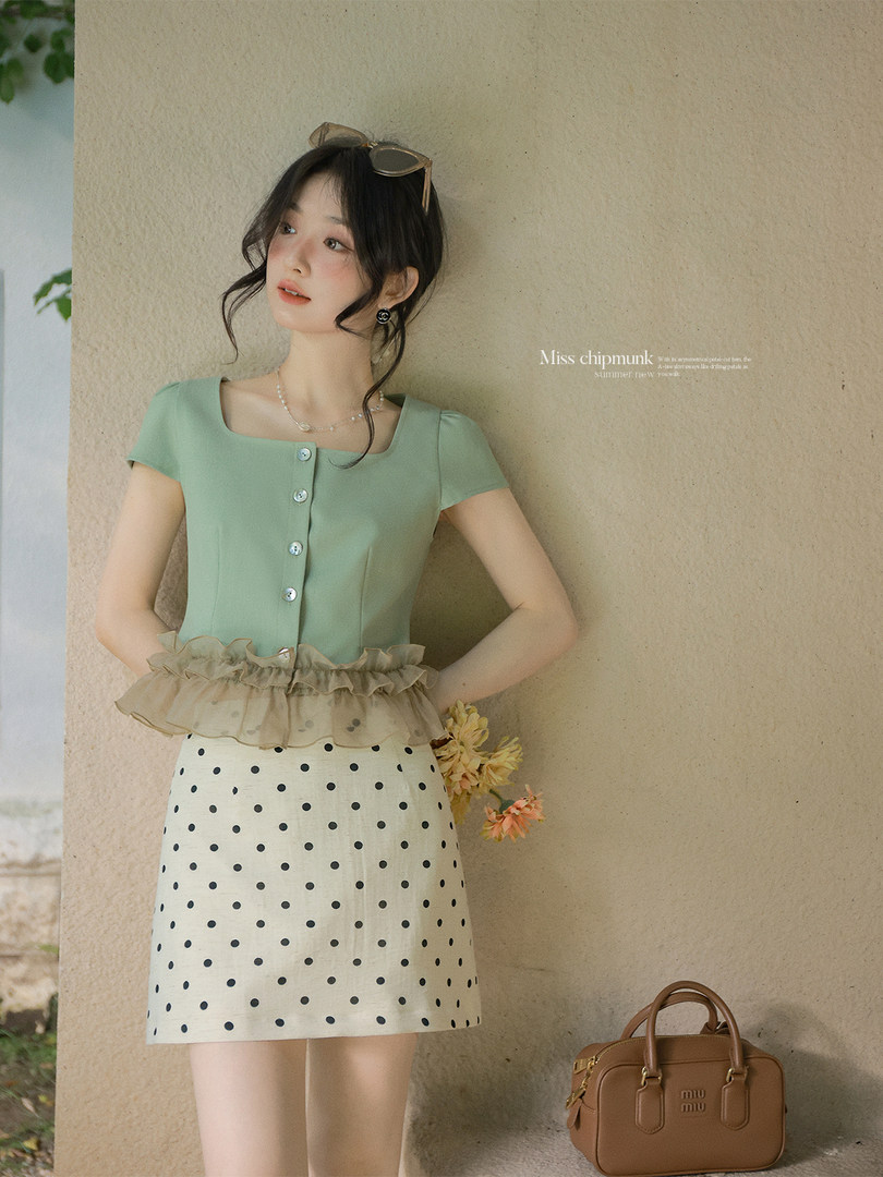 Woman wearing a mint green top and polka dot skirt outfit
